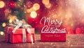 Red Merry Christmas and happy new year handwriting with xmas tree and gift box at blur bokeh light background,Winter holiday Royalty Free Stock Photo