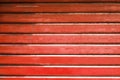 Red metal automatic garage shutter closeup, steel striped sliding door, texture and pattern, old and weathered surface, dirty