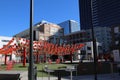 Red metal chairs with red Chinese lanterns hanging from the sky surrounded by red brick office buildings and shops