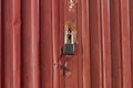 Red metal door closed on the lock corrugated steel fence gate padlock garage shed in Sofia, Bulgaria, Eastern Europe Royalty Free Stock Photo