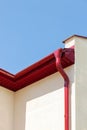 Red metal drainpipe newly installed on wall