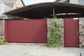 Red metal gate and closed door on a gray stone wall Royalty Free Stock Photo