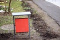 Red metal litter bin on the sidewalk