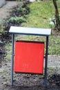 Red metal litter bin on the sidewalk