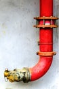 Red metal pipe extinguishing water on concrete wall. Emergency fire valve or Y shape hose tube in the building. Safety equipment a Royalty Free Stock Photo