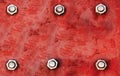 Red metal plate painted with light red and grey colours and fixed with six large steel bolt screws in parallel lines as texture ba