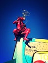 Red metal sculpture atop building