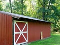 Red metal shed on farm with sliding door with white trim Royalty Free Stock Photo