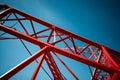 Red metal structure against blue sky background with plane flying overhead. Generative AI Royalty Free Stock Photo