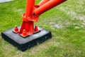 This is a red metal support or pole attached to the concrete base with large anchor bolts and nuts. Royalty Free Stock Photo