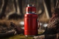 red metal thermos on a stump on a tree in the forest Royalty Free Stock Photo