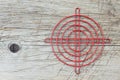 Red metallic crosshair on an old wooden surface