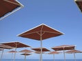 Red metallic parasol beach umbrellas over blue sky Royalty Free Stock Photo