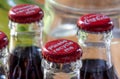 Red metals caps on the top of retro style coca cola bottles carrying the message `Please recycle me`.