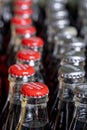 Red metals caps on the top of retro style coca cola bottles carrying the message `Please recycle me`. Royalty Free Stock Photo