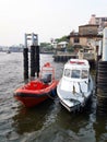 Red military patrol boat and ambulance boat parked at river port