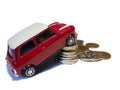 Red mini toy car against pile of British coins