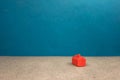 red miniature house standing alone on a blue background, the concept of wealth, success Royalty Free Stock Photo