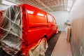 Red minivan in paint booth. Car workshop details, painting of a car Royalty Free Stock Photo