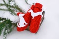 Red mittens, dog figures and green fir tree branches in wooden decorative box on snow. Royalty Free Stock Photo