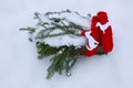 Red mittens, dog figures and green fir tree branches in wooden decorative box on snow. Royalty Free Stock Photo