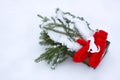 Red mittens, dog figures and green fir tree branches in wooden decorative box on snow. Royalty Free Stock Photo