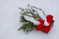 Red mittens, paper dog figure and green fir tree branches in wooden box on snow. Royalty Free Stock Photo