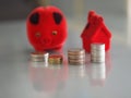 Many coins are stacked rows orderly reflection on blurred background and red pig coin bank, piggy bank, money box and red model ho Royalty Free Stock Photo