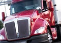 Red modern big rig semi truck with shiny grille and painted surf Royalty Free Stock Photo