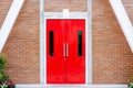 Red modern door with long stainless handle on brick wall at modern building Royalty Free Stock Photo
