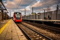 Red modern high speed train arrives on the railway station. Passenger train on railroad Royalty Free Stock Photo