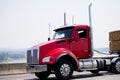 Red modern semi truck with day cab and flat bed trailer carry lu Royalty Free Stock Photo