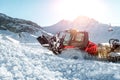 Red modern snowcat ratrack with snowplow snow grooming machine preparing ski slope piste hill at alpine skiing winter Royalty Free Stock Photo