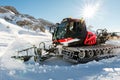 Red modern snowcat ratrack with snowplow snow grooming machine preparing ski slope piste hill at alpine skiing winter Royalty Free Stock Photo