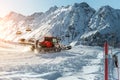 Red modern snowcat ratrack with snowplow snow grooming machine preparing ski slope piste hill at alpine skiing winter Royalty Free Stock Photo