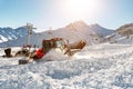 Red modern snowcat ratrack with snowplow snow grooming machine preparing ski slope piste hill at alpine skiing winter Royalty Free Stock Photo