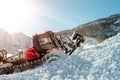 Red modern snowcat ratrack with snowplow snow grooming machine preparing ski slope piste hill at alpine skiing winter Royalty Free Stock Photo