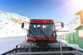 Red modern snowcat ratrack with snowplow snow grooming machine preparing ski slope piste hill at alpine skiing winter Royalty Free Stock Photo