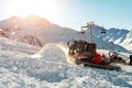 Red modern snowcat ratrack with snowplow snow grooming machine preparing ski slope piste hill at alpine skiing winter Royalty Free Stock Photo