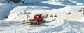 Red modern snowcat ratrack with snowplow snow grooming machine preparing ski slope piste hillalpine skiing winter resort Royalty Free Stock Photo