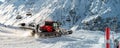 Red modern snowcat ratrack with snowplow snow grooming machine preparing ski slope piste hillalpine skiing winter resort Royalty Free Stock Photo