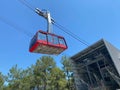 Red modern tourist cabin of the cable car ascends the mountains against the blue sky Royalty Free Stock Photo