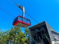 Red modern tourist cabin of the cable car ascends the mountains against the blue sky Royalty Free Stock Photo