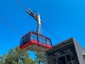 Red modern tourist cabin of the cable car ascends the mountains against the blue sky Royalty Free Stock Photo