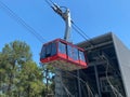 Red modern tourist cabin of the cable car ascends the mountains against the blue sky Royalty Free Stock Photo