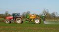 Red modern tractor pulling a crop sprayer Royalty Free Stock Photo