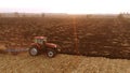 Red modern tractor working on farm field. Royalty Free Stock Photo