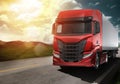 Red modern truck moving fast on the road at sunset with natural landscape Royalty Free Stock Photo