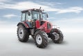 Modern wheeled tractor isolated on bright background with sky