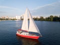 Red modern yacht with open sails